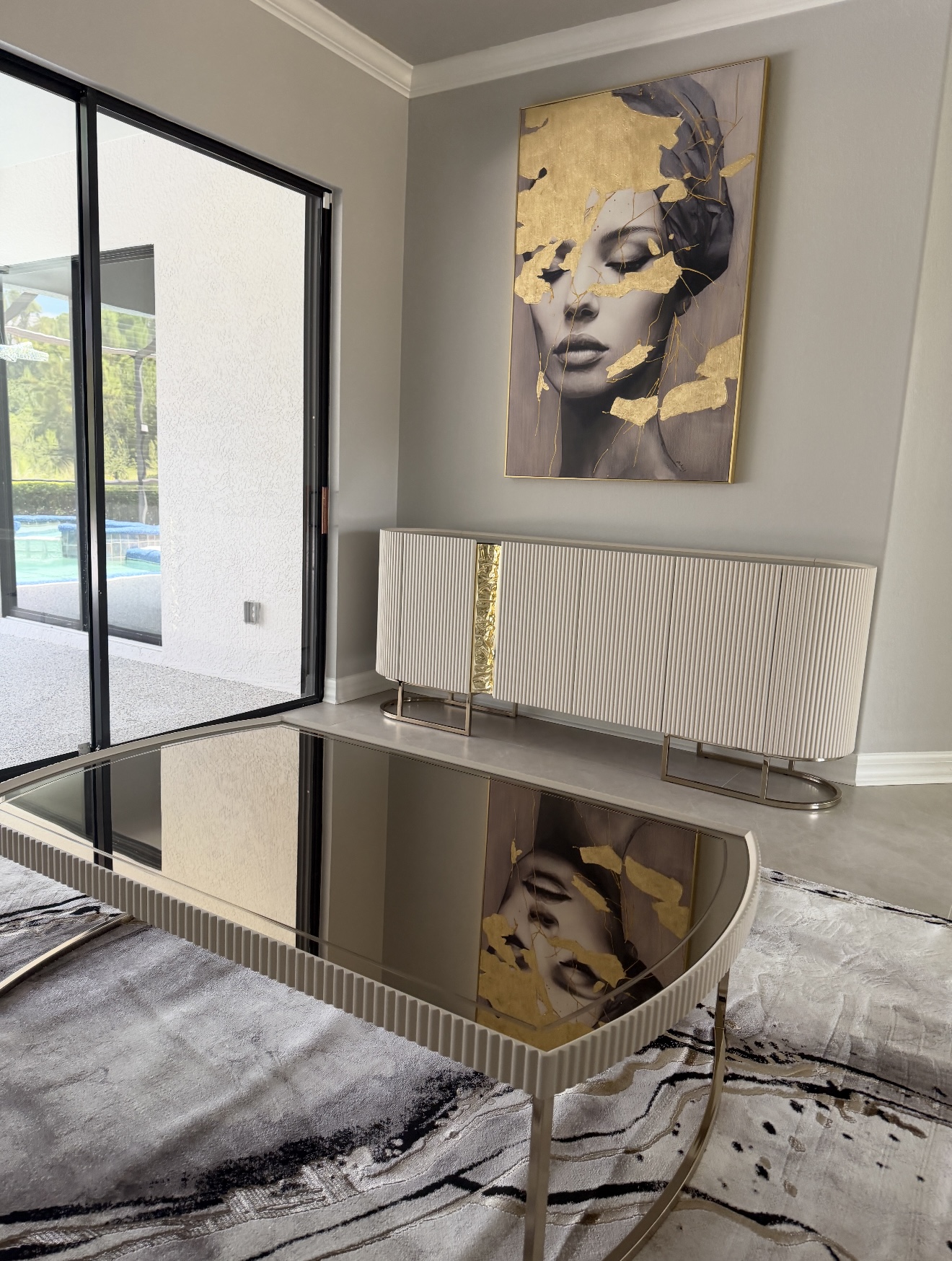 A reflective coffee table and matching sideboard in a neatly arranged living room